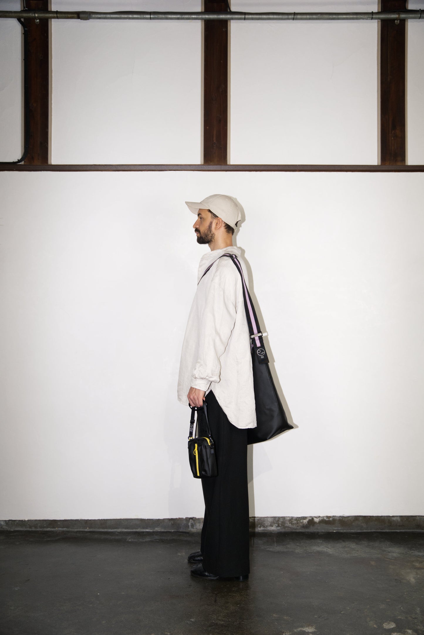 male model holding the BOX Cactus Leather Mini Bag in yellow