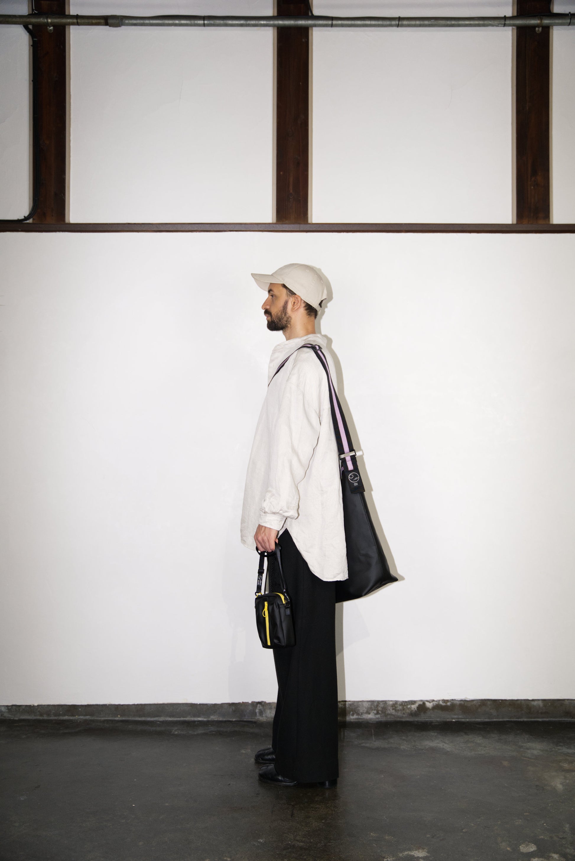 male model holding the BOX Cactus Leather Mini Bag in yellow