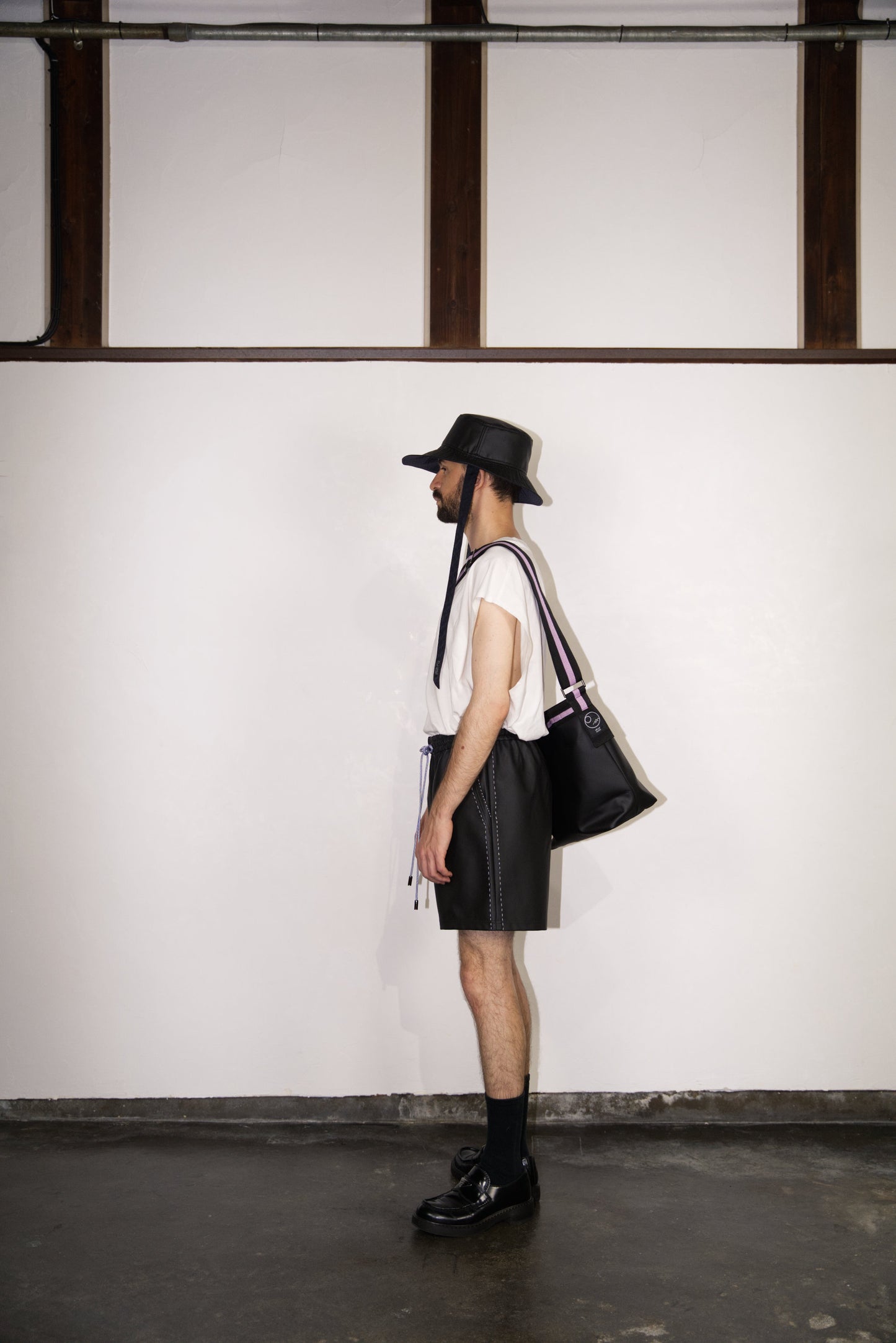 male model wearing the light purple hand-stitched scene cactus leather shorts from the side