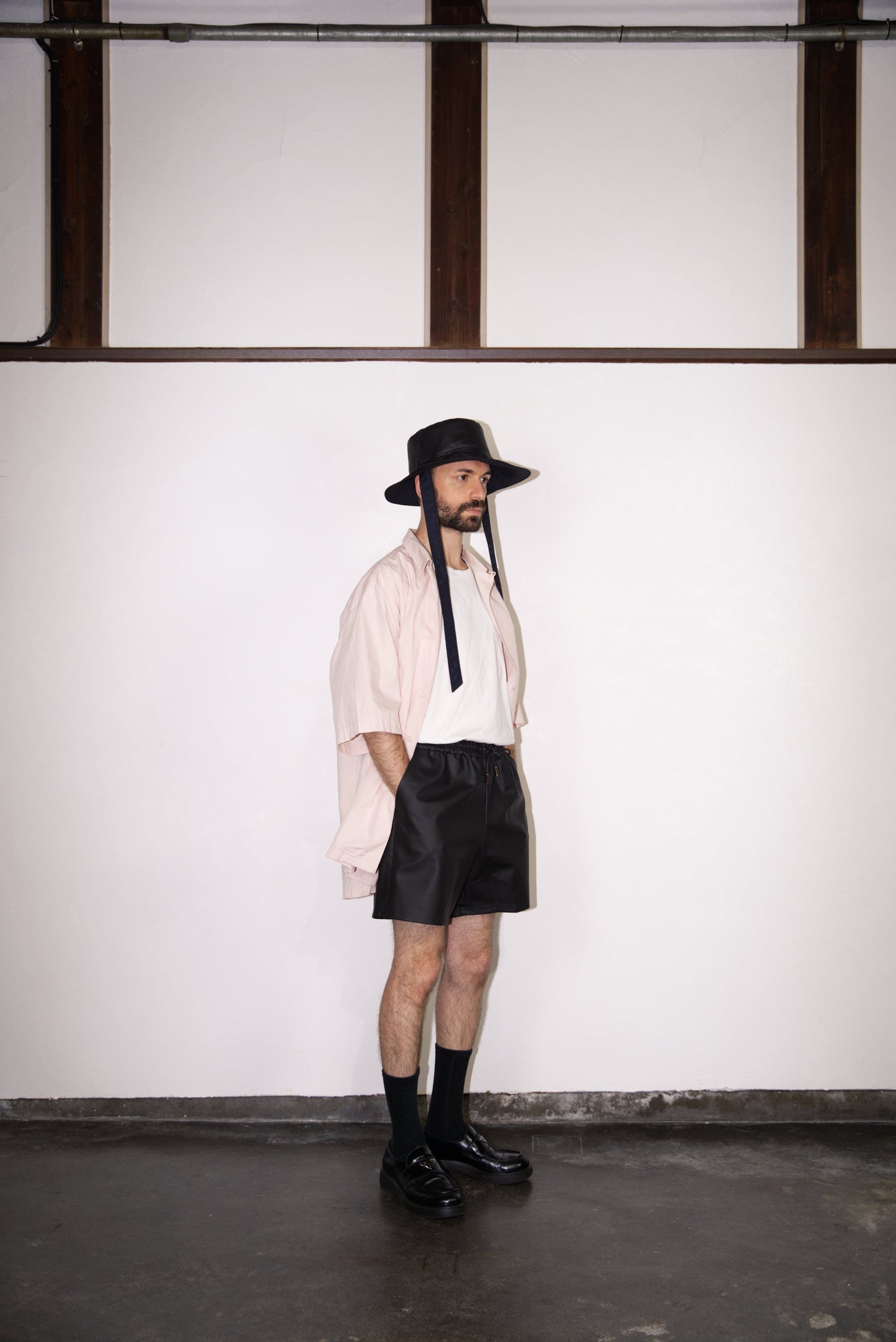 matt black SCENE Cactus Leather Shorts on male mode wearing hat and pink shirt