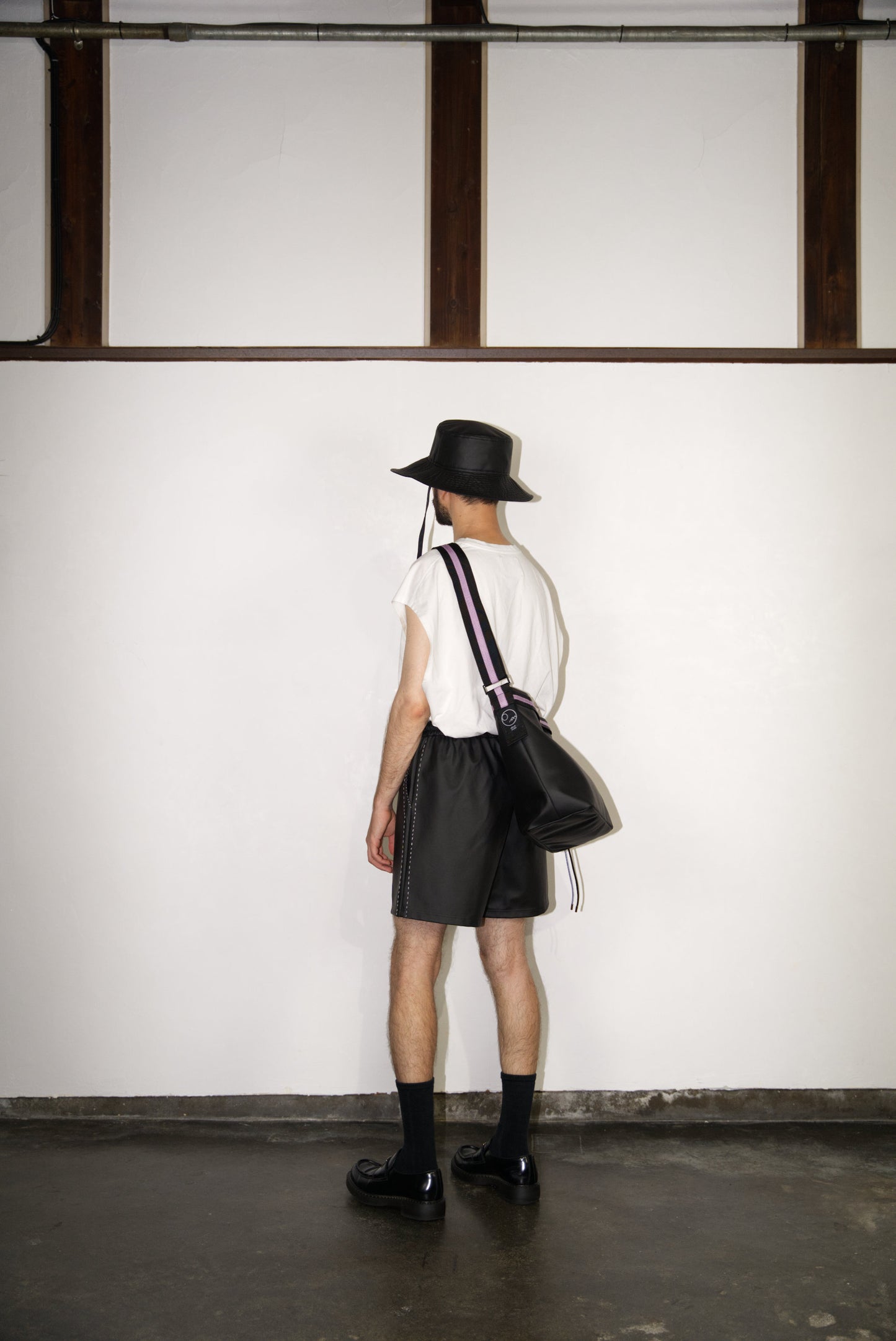 male model wearing the light purple hand-stitched scene cactus leather shorts from the back