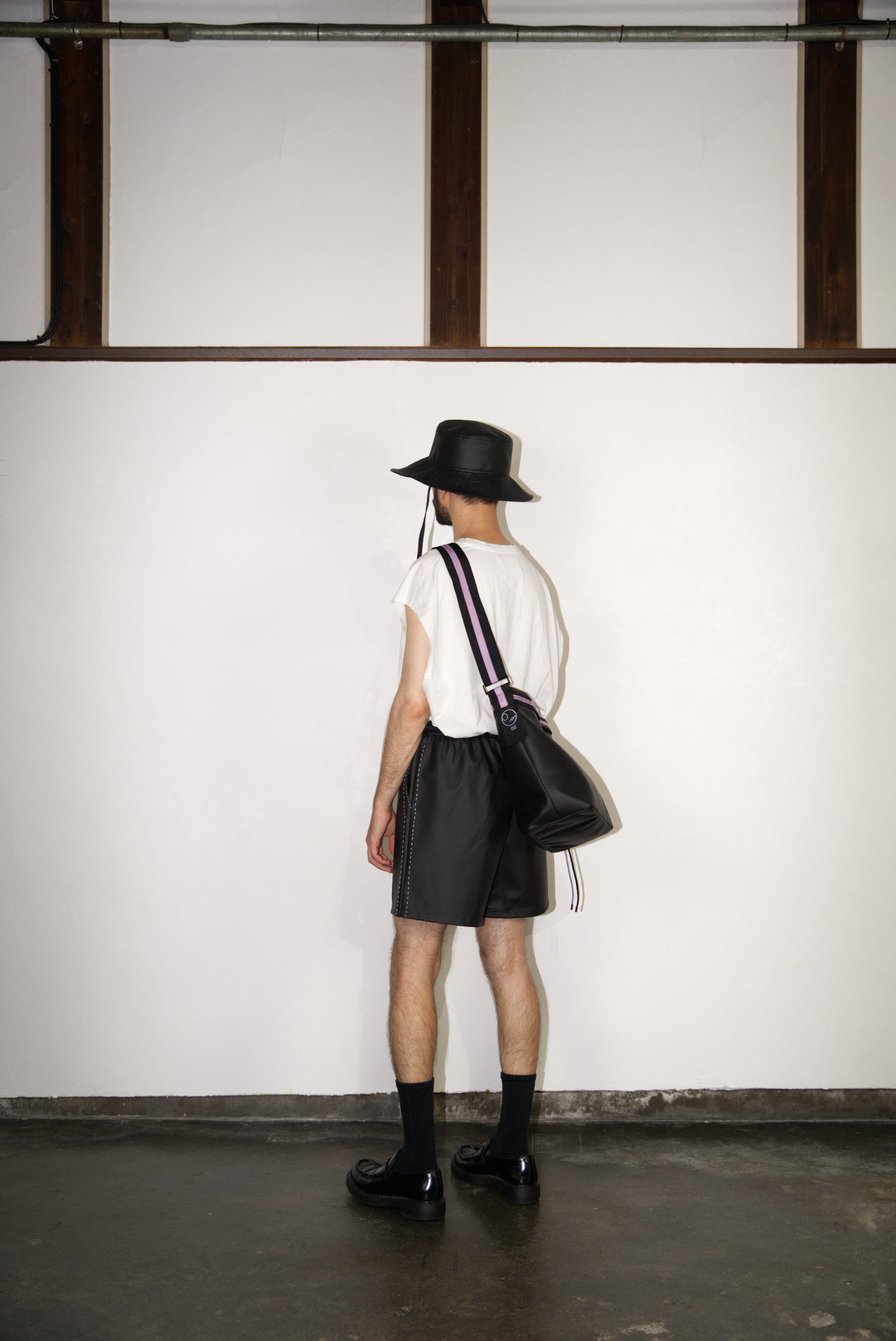 male model wearing the light purple hand-stitched scene cactus leather shorts from the back