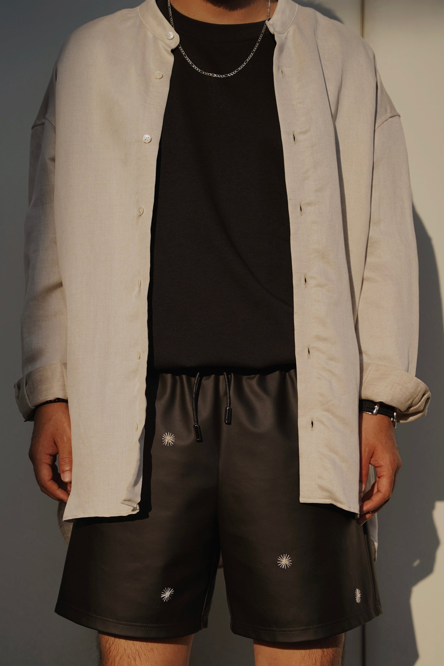 male model wears hand-stitched scene cactus leather shorts in black