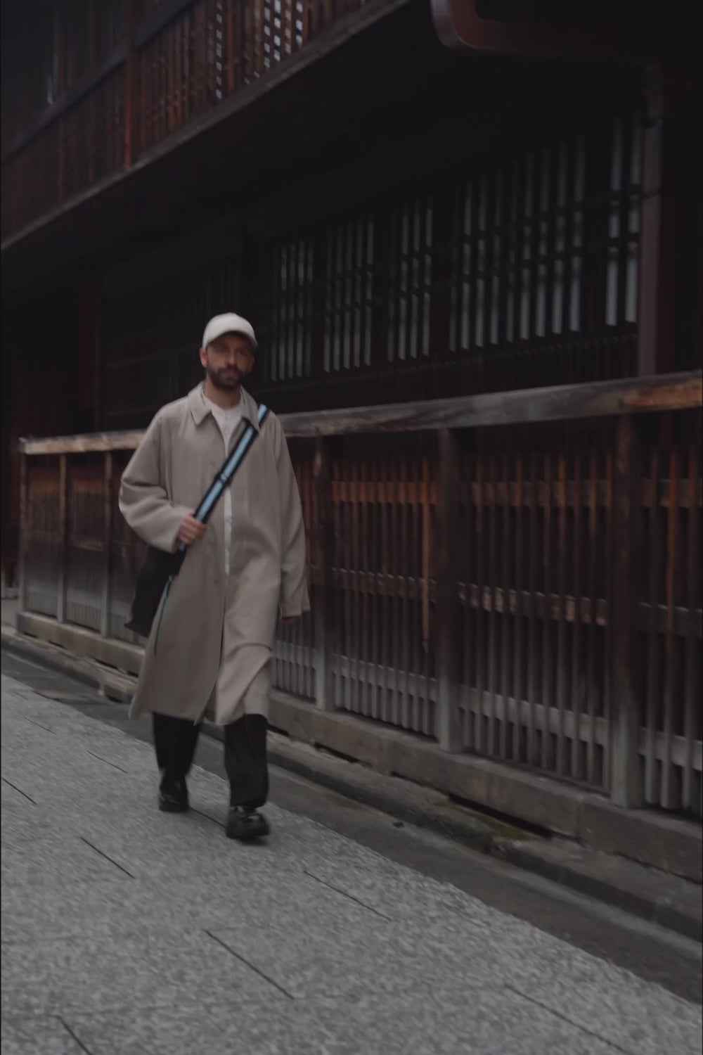 male model holding the Large Helmet Bag in Cactus Leather and walking down the street