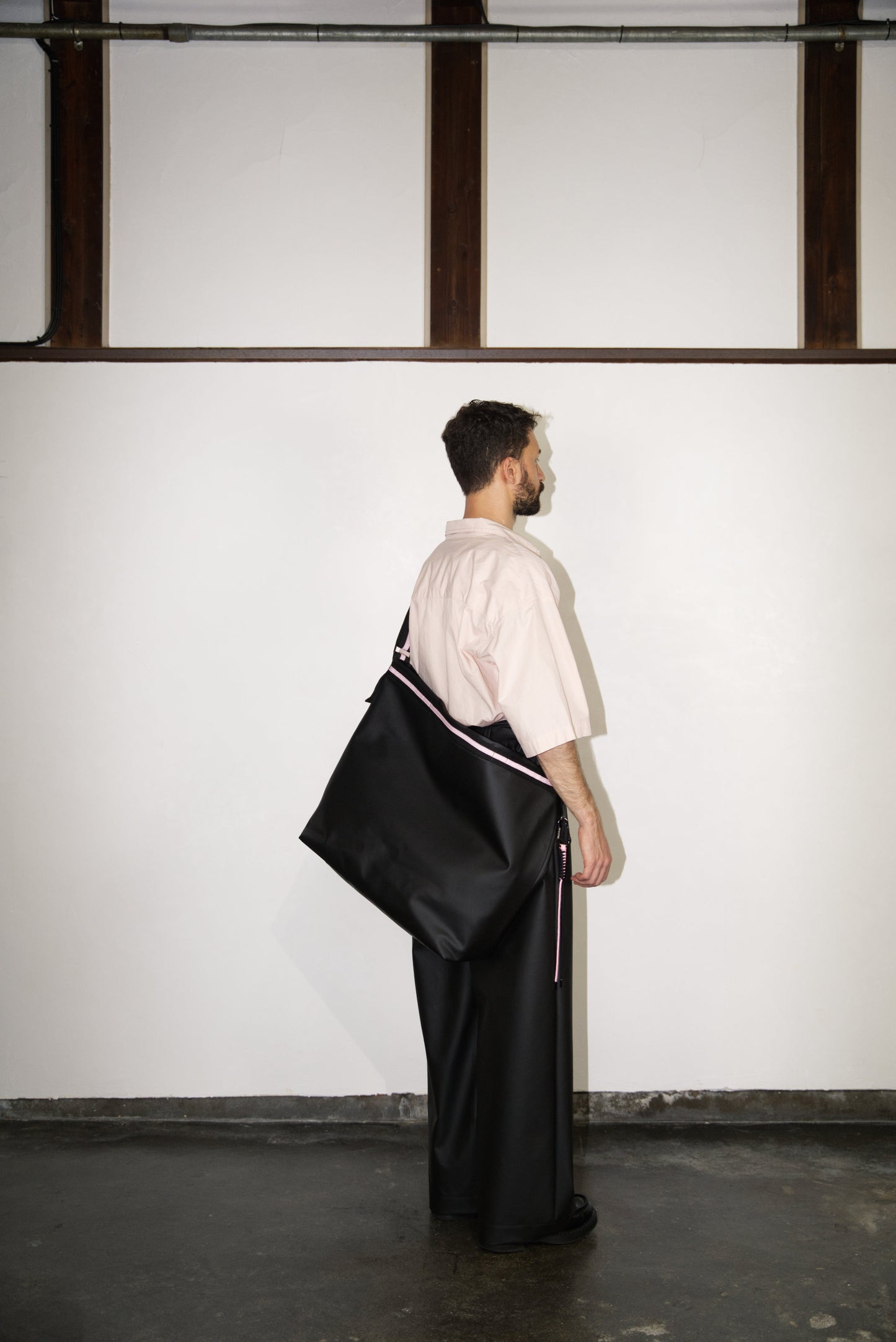 male model wearing the Large Helmet Bag in Cactus Leather in pink 