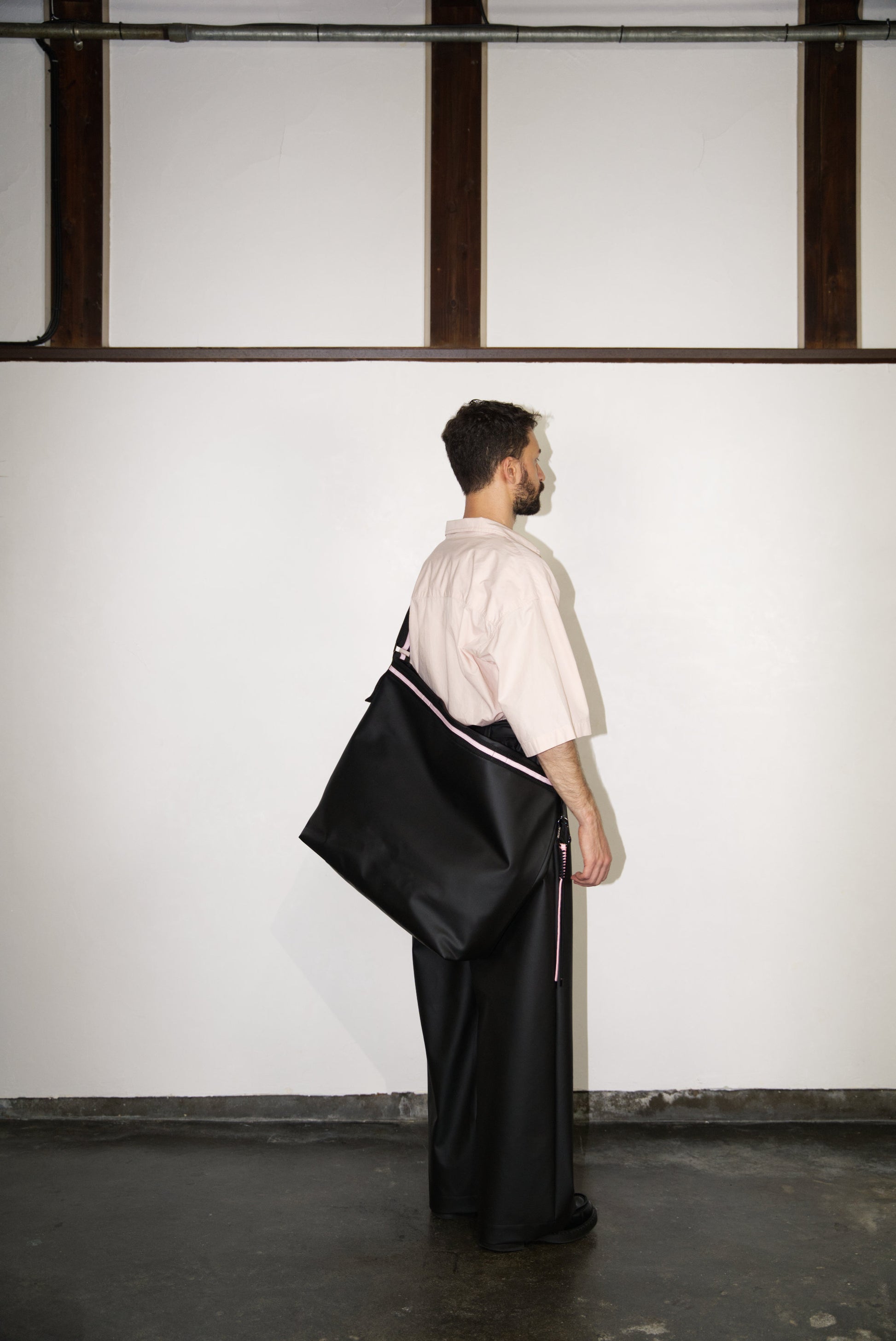 male model wearing the Large Helmet Bag in Cactus Leather in pink 