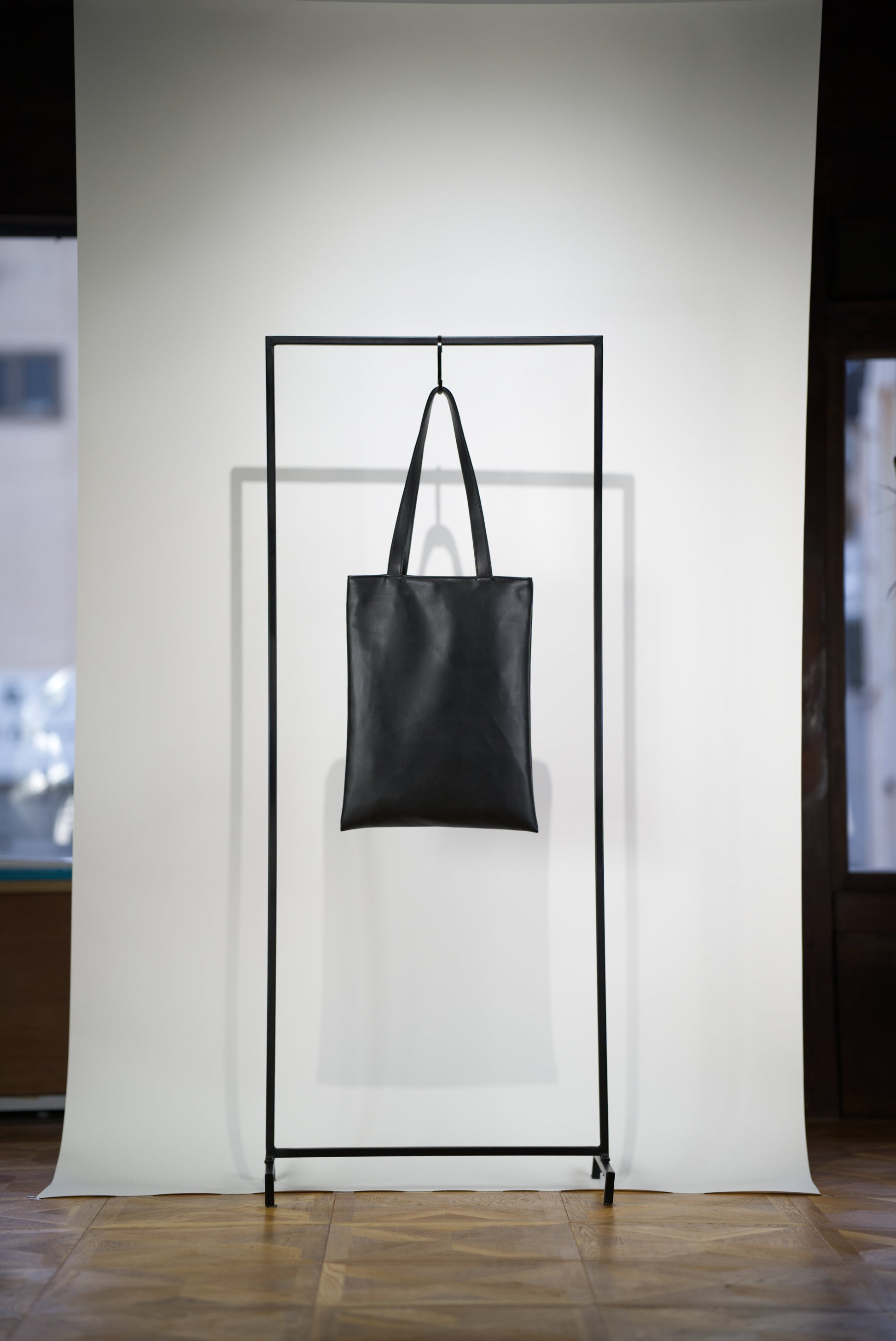 VOID Tote Bag in Cactus Leather hanging on a rack from the back