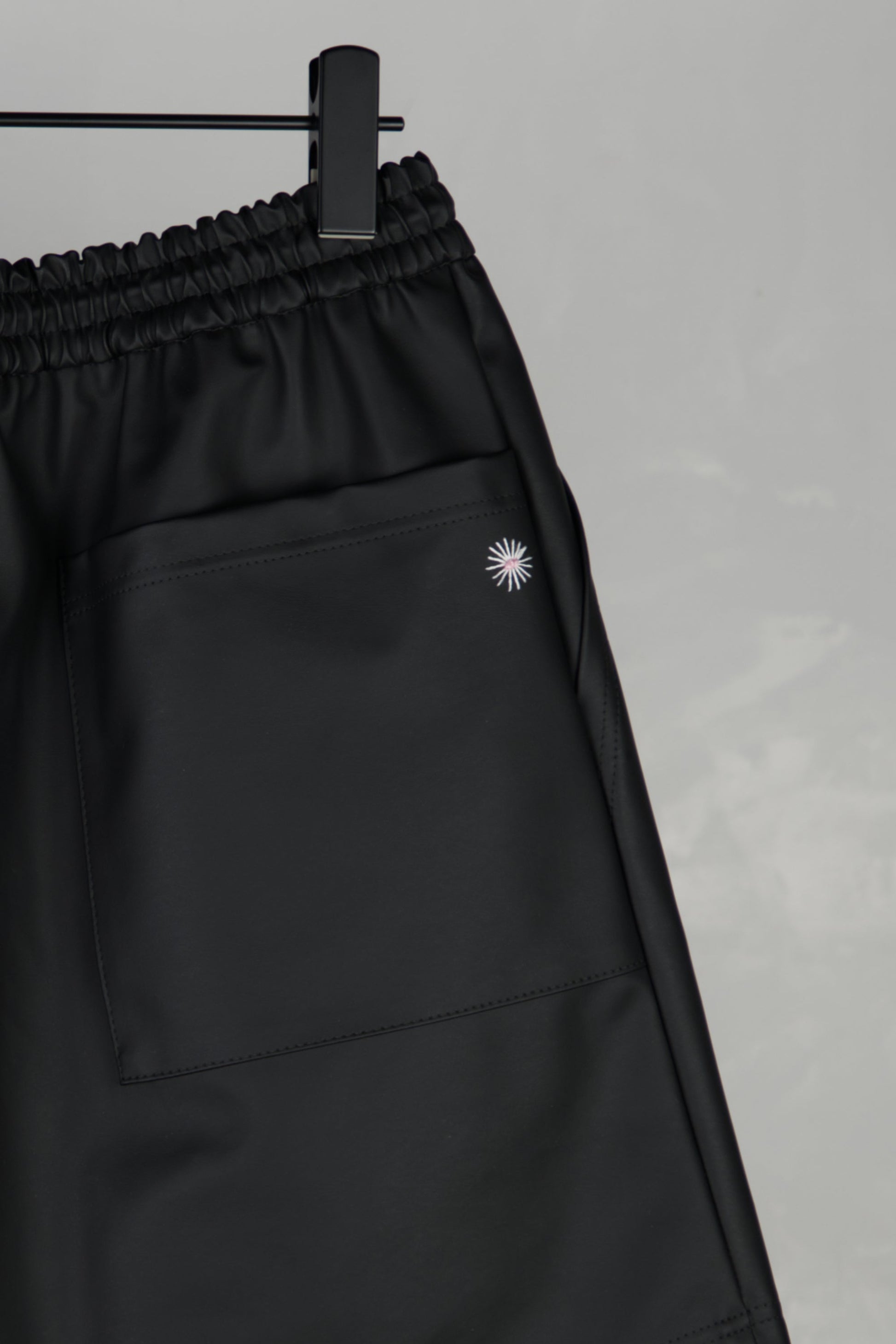 close up of hand-stitched detail of scene cactus leather shorts in black
