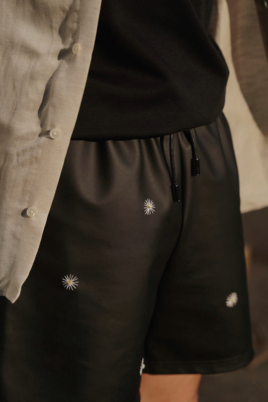 front side of hand-stitched scene cactus leather shorts in black on model