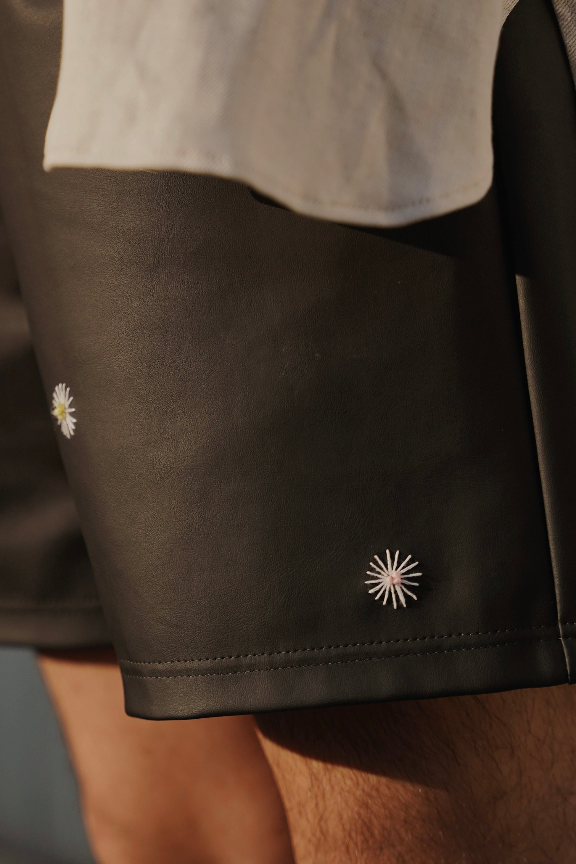 hand-stitched details on scene cactus leather shorts in black on model